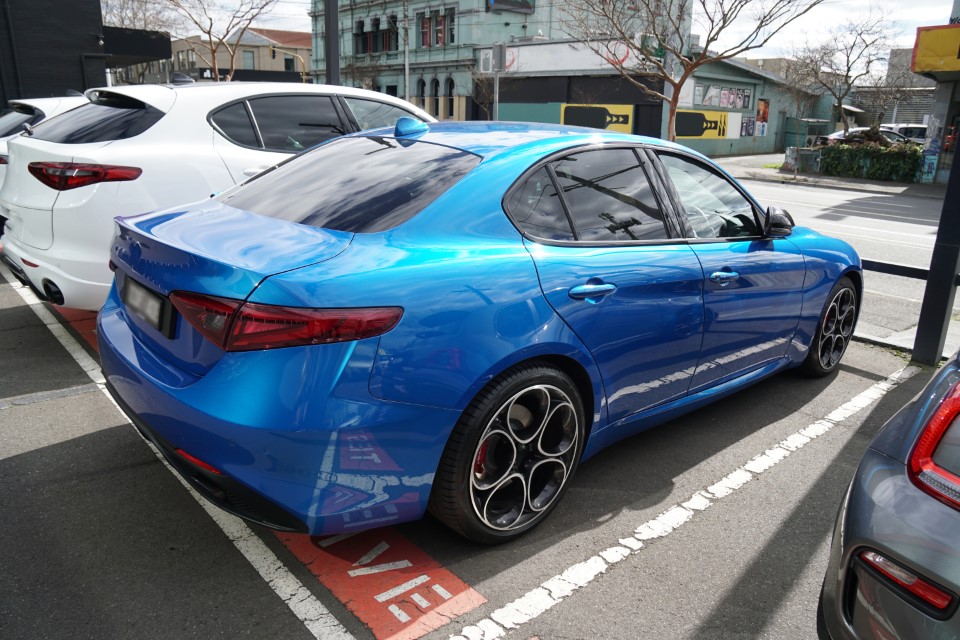 A blue sedan, parked in an urban area.