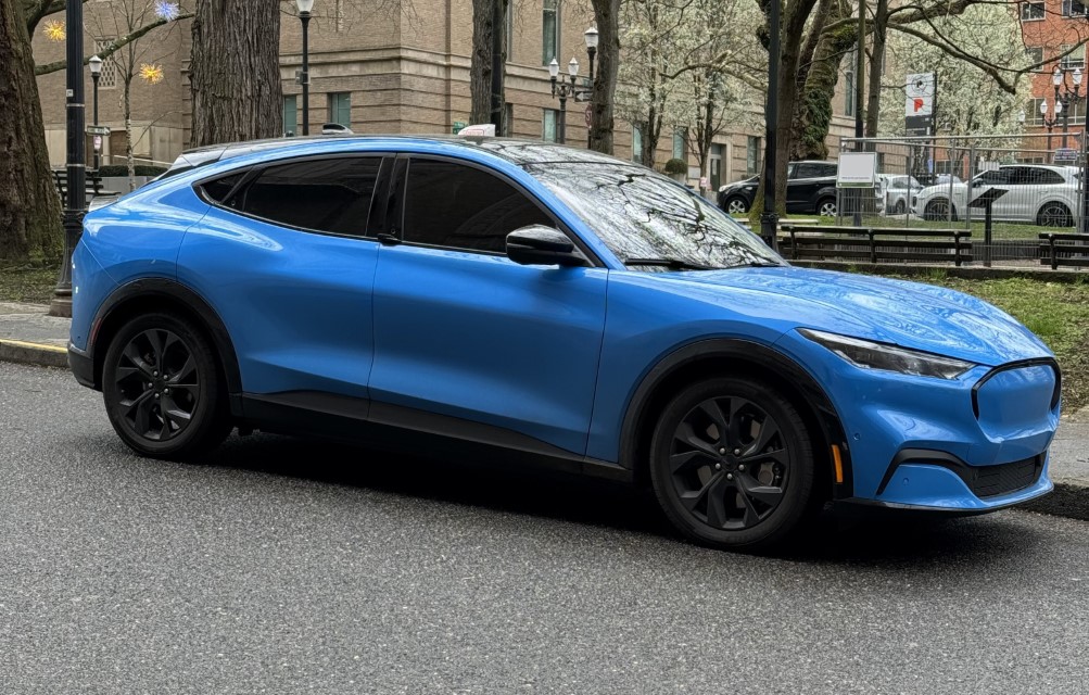 A blue electric sporty crossover, parked on a city street.