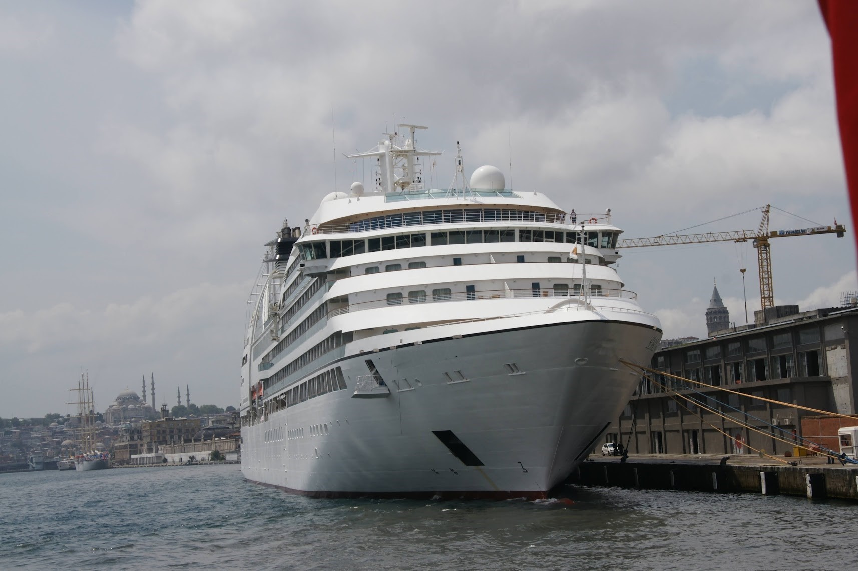 A large white cruise ship docked at a port.