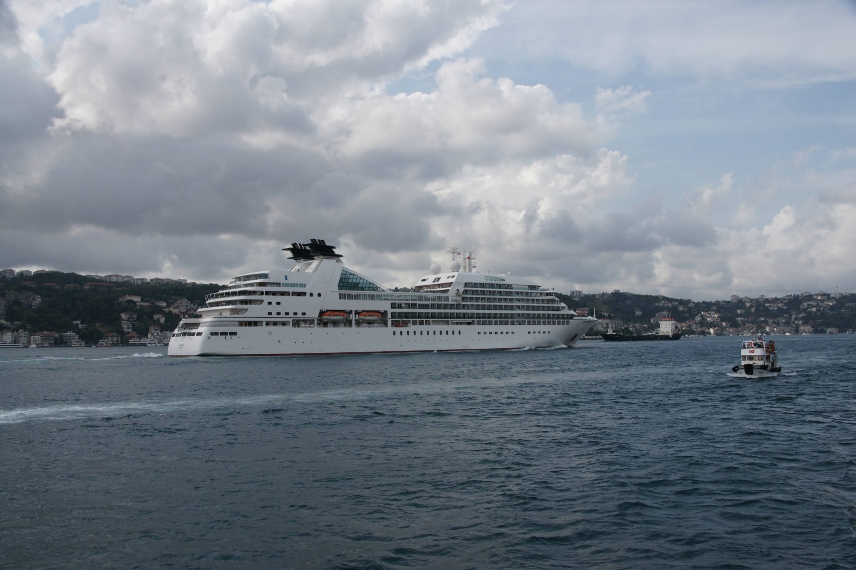 A white cruise ship cruising through a waterway.