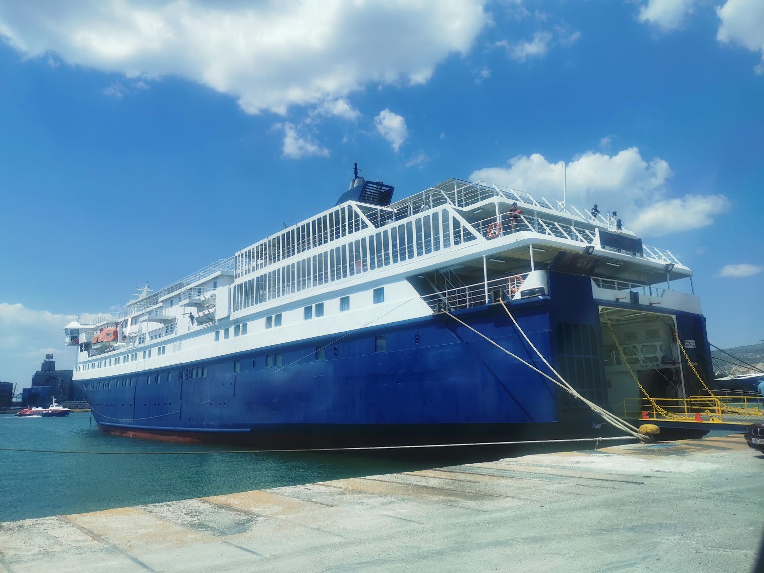 A large blue ferry docked at a port.